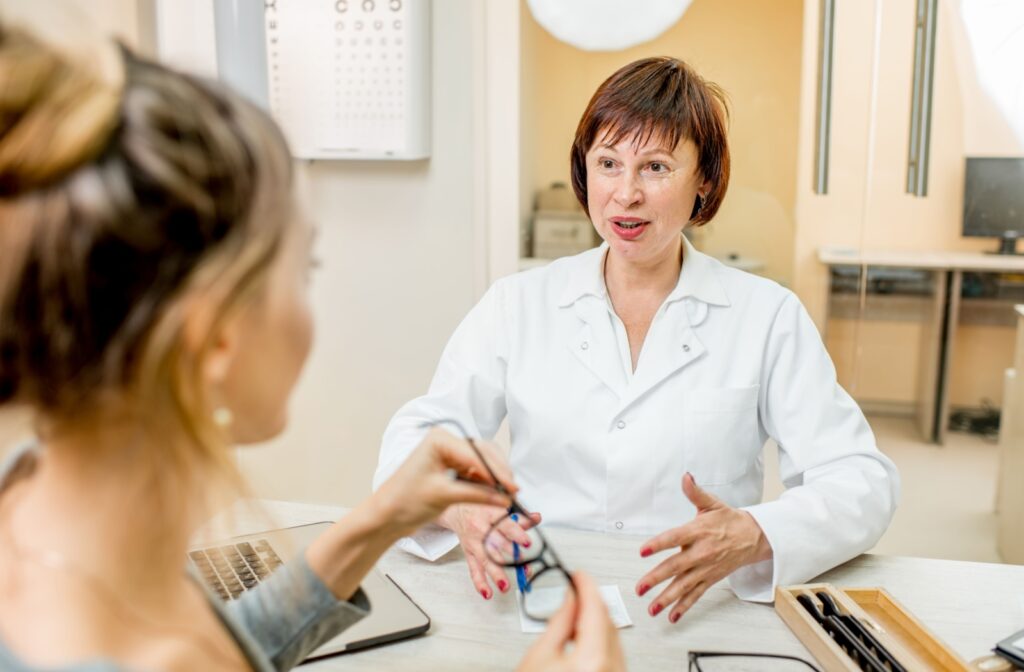 An optometrist talks to their patient about anti-reflective prescription eyeglasses.