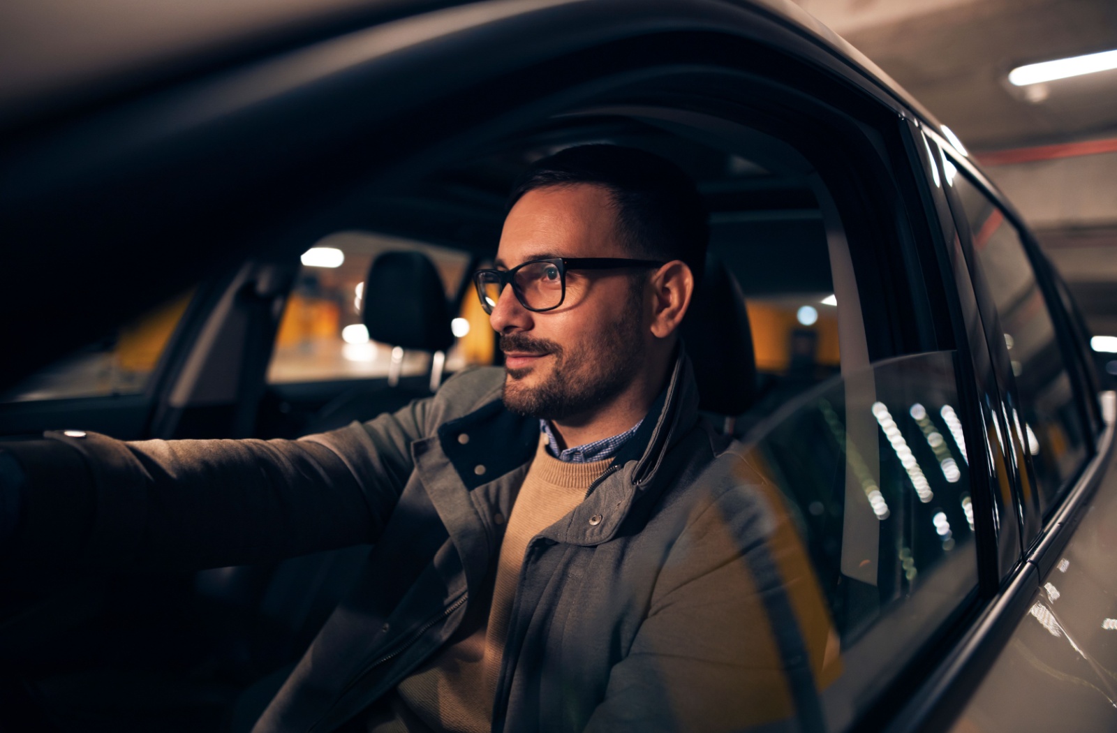 A person wearing anti-reflective glasses while driving at night.