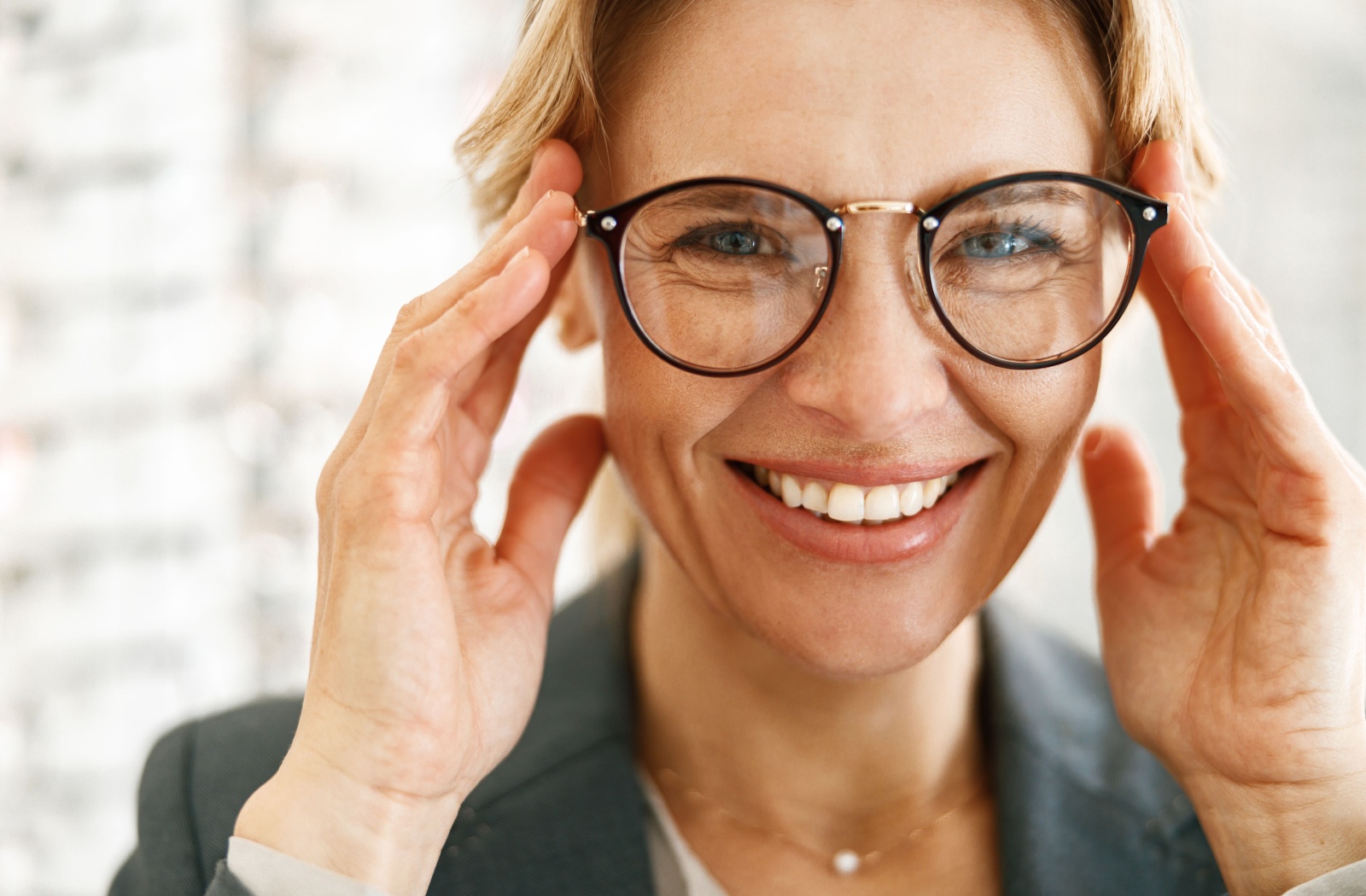 A happy person smiling in their new, perfectly fitting eyeglasses.