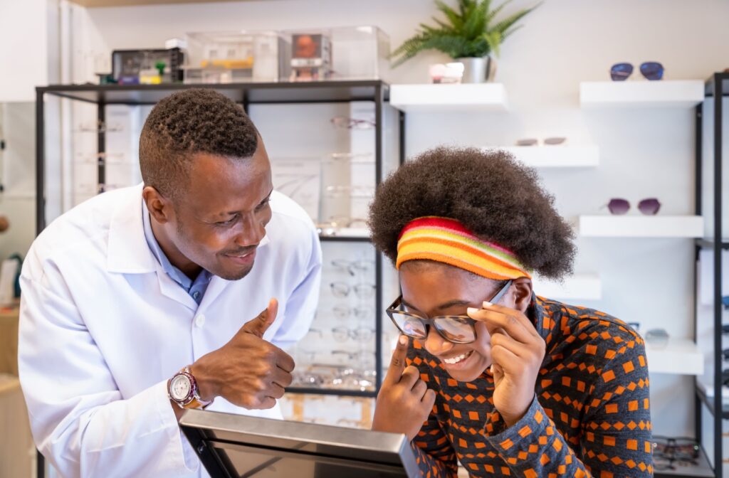An optician helps a patient find eyeglass frames that fit comfortably snug.