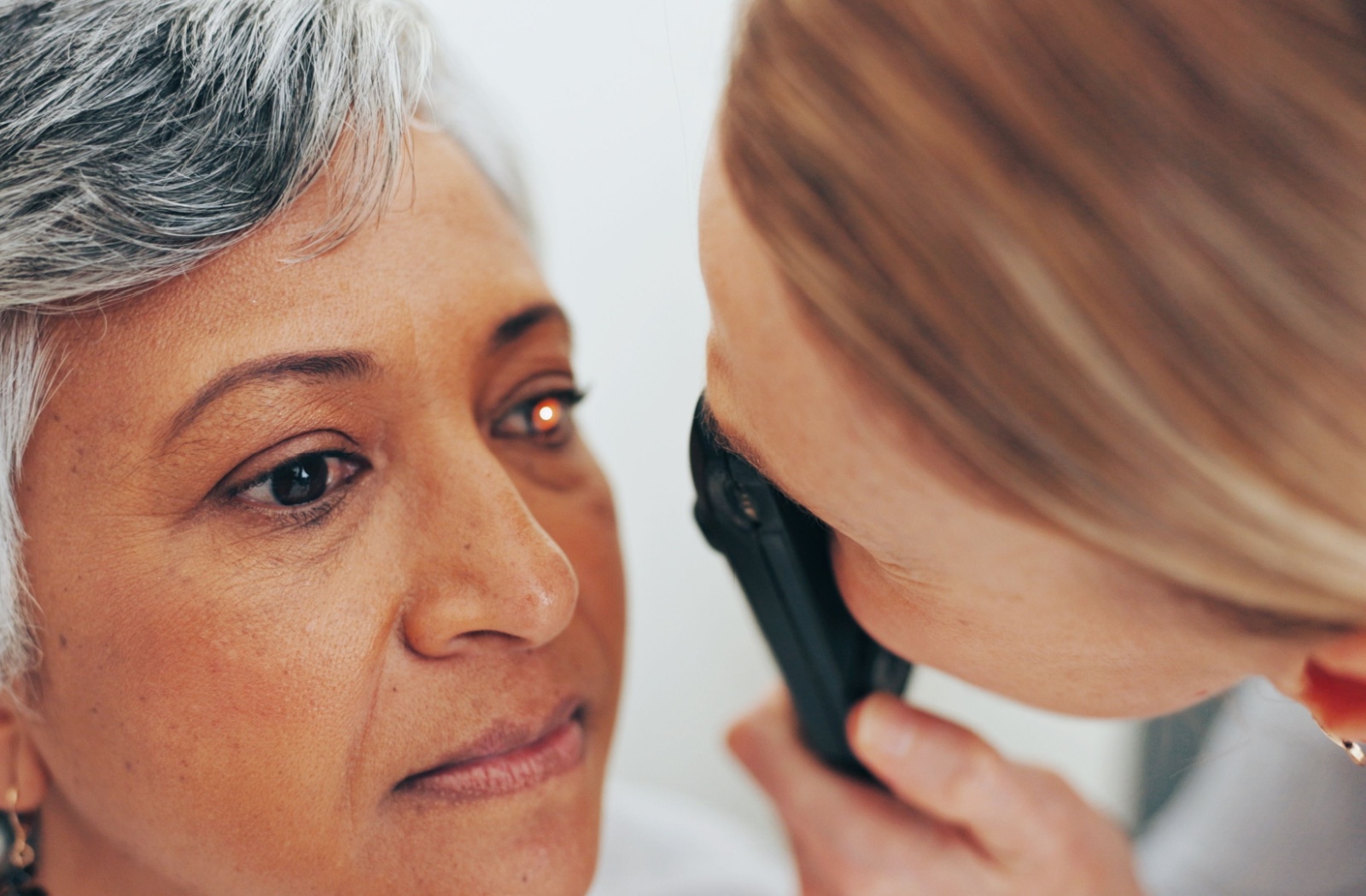 Close up of an eye doctor using a tool to look better at a patients eye